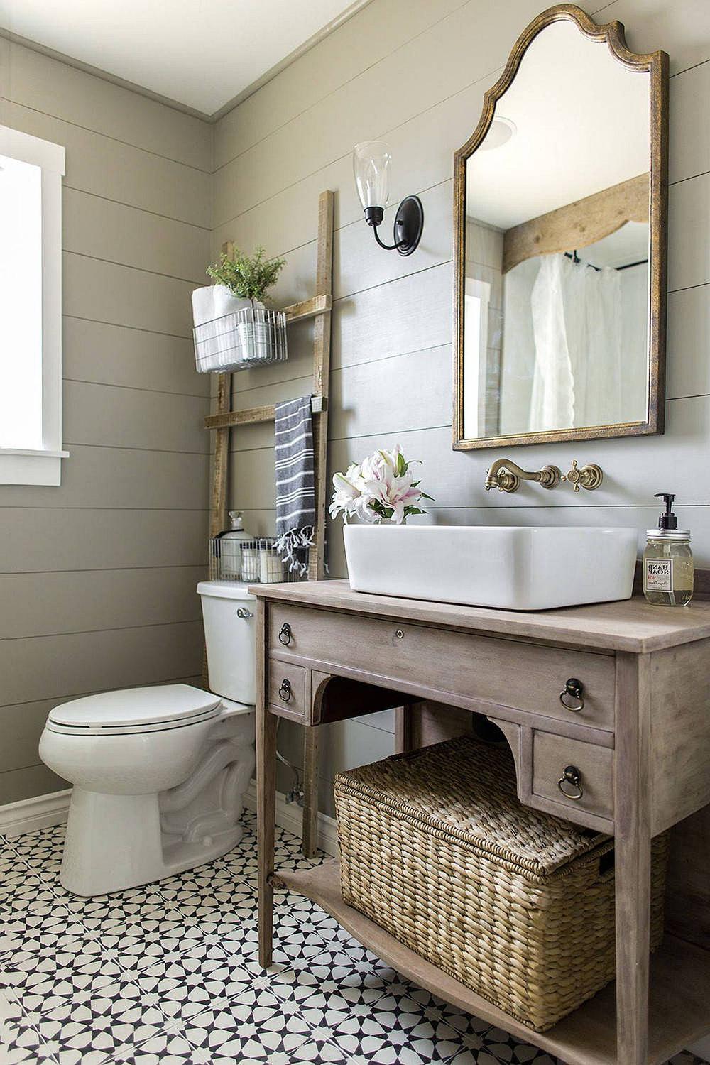 Farmhouse bathroom featuring gray shiplap, industrial lighting, and a vintage mirror.