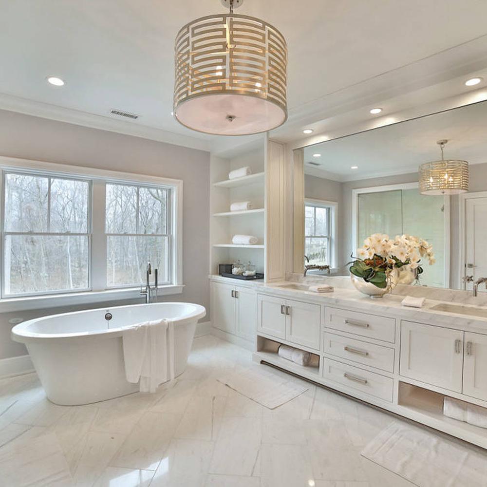 A spacious and elegantly designed feminine bathroom featuring soft gray walls, a freestanding tub, large windows, and modern lighting elements.
