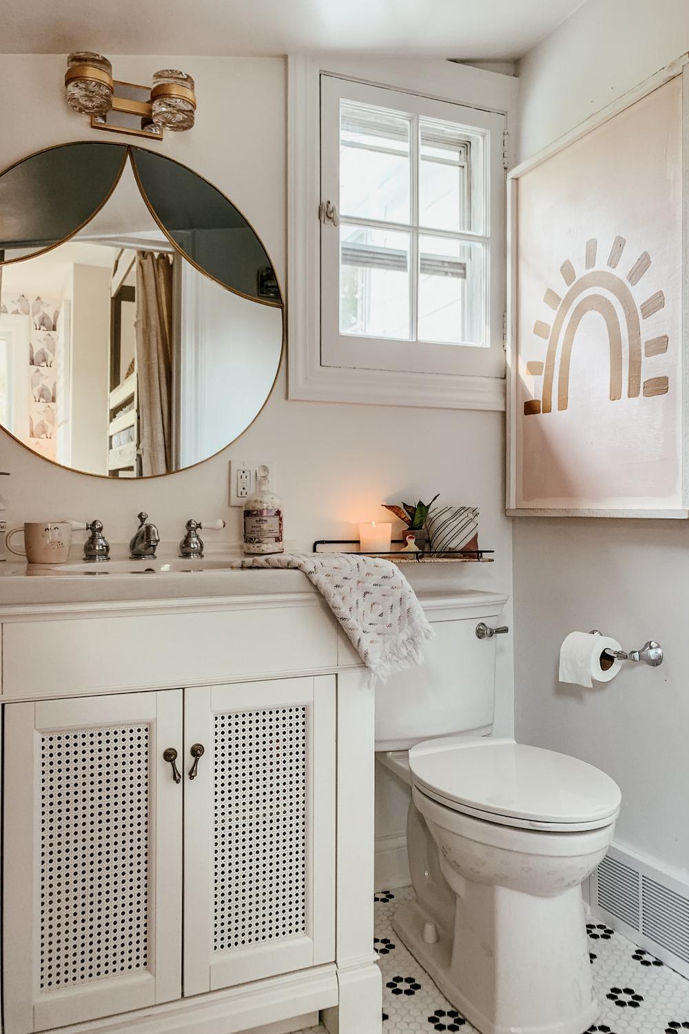 A modern feminine bathroom featuring a sleek vanity, unique mirrors, and patterned black and white flooring.