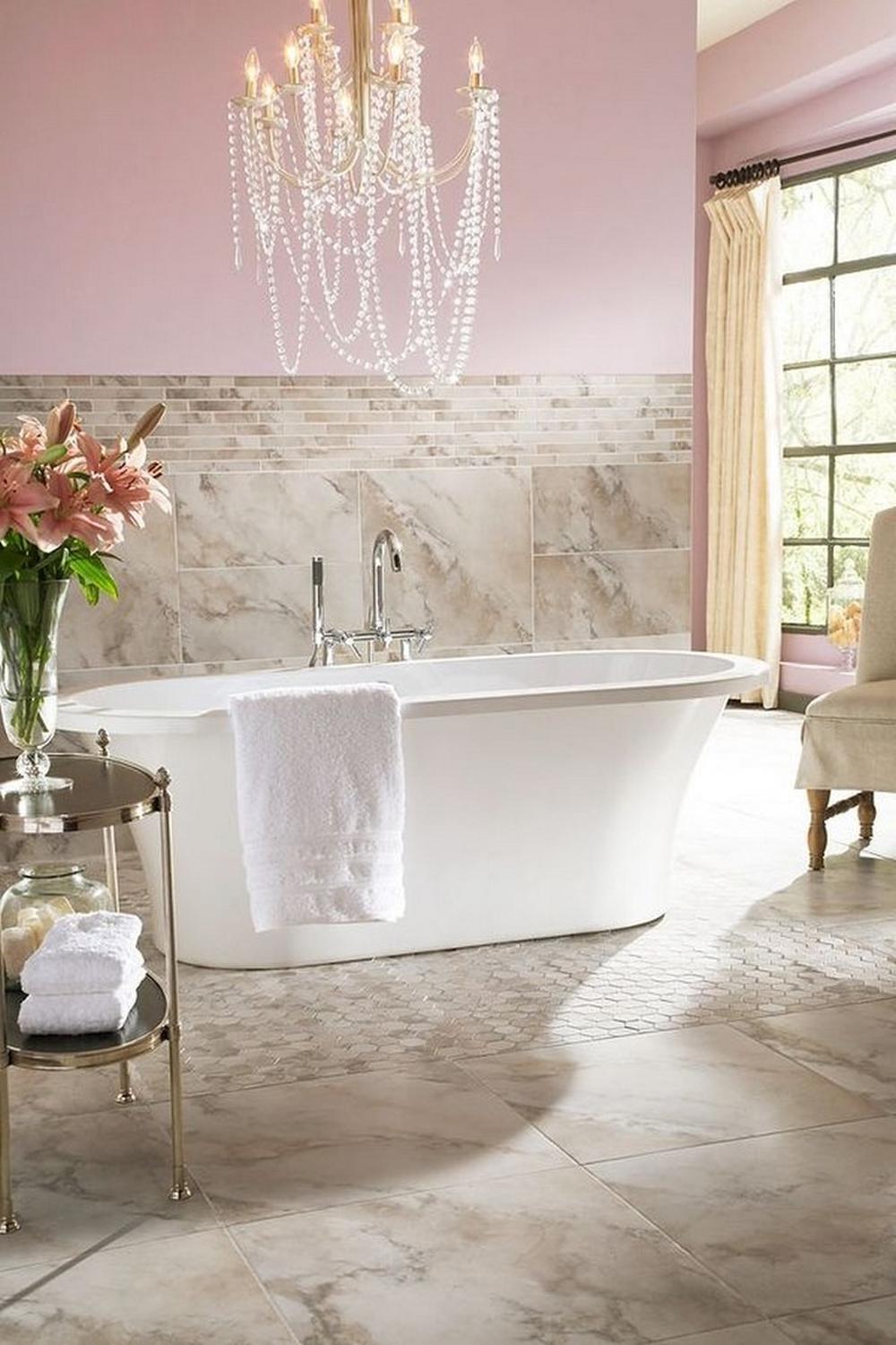 An elegant feminine bathroom design featuring a freestanding bathtub, chandelier lighting, and a soft pink color scheme.