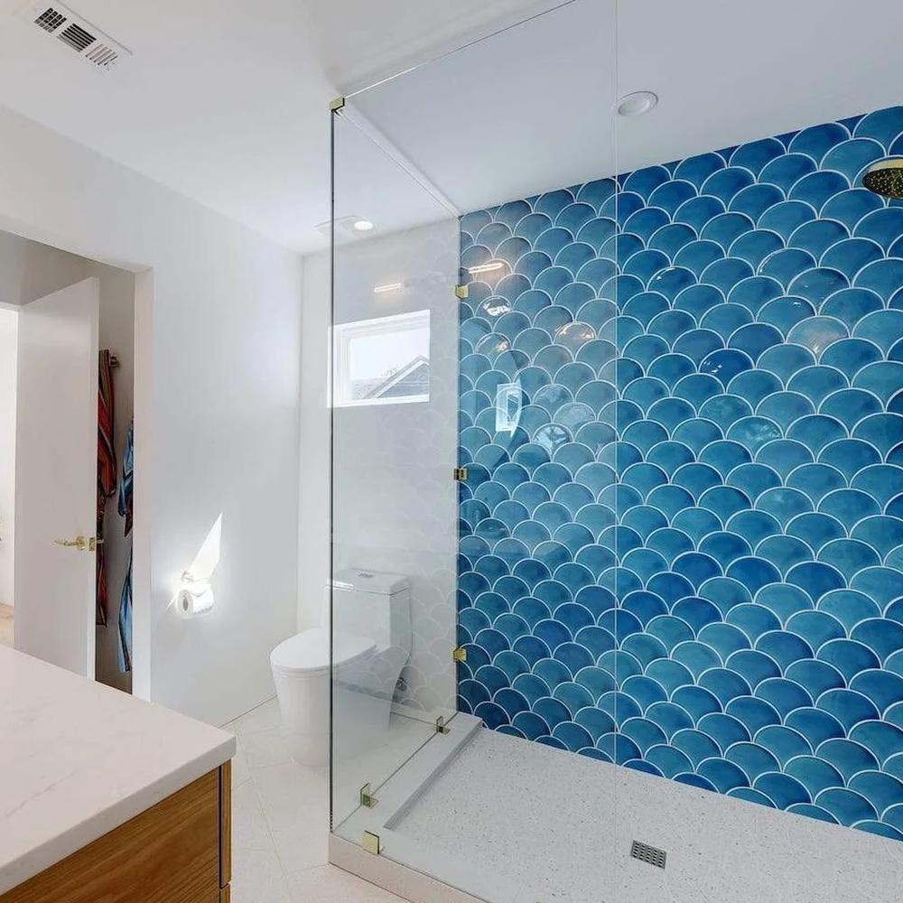 Spacious bathroom with shower featuring fish scale tile design in gradients of blue