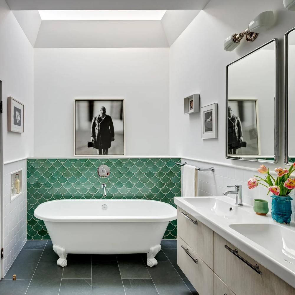 Sophisticated bathroom featuring lush green fish scale tiles and vintage accents