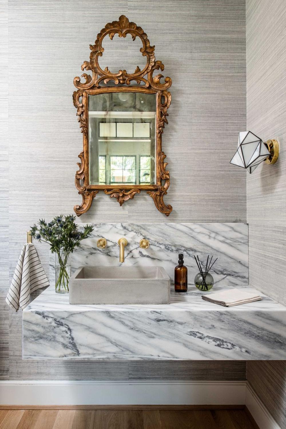 A sleek floating vanity featuring a marble countertop paired with a minimalist rectangular concrete sink.