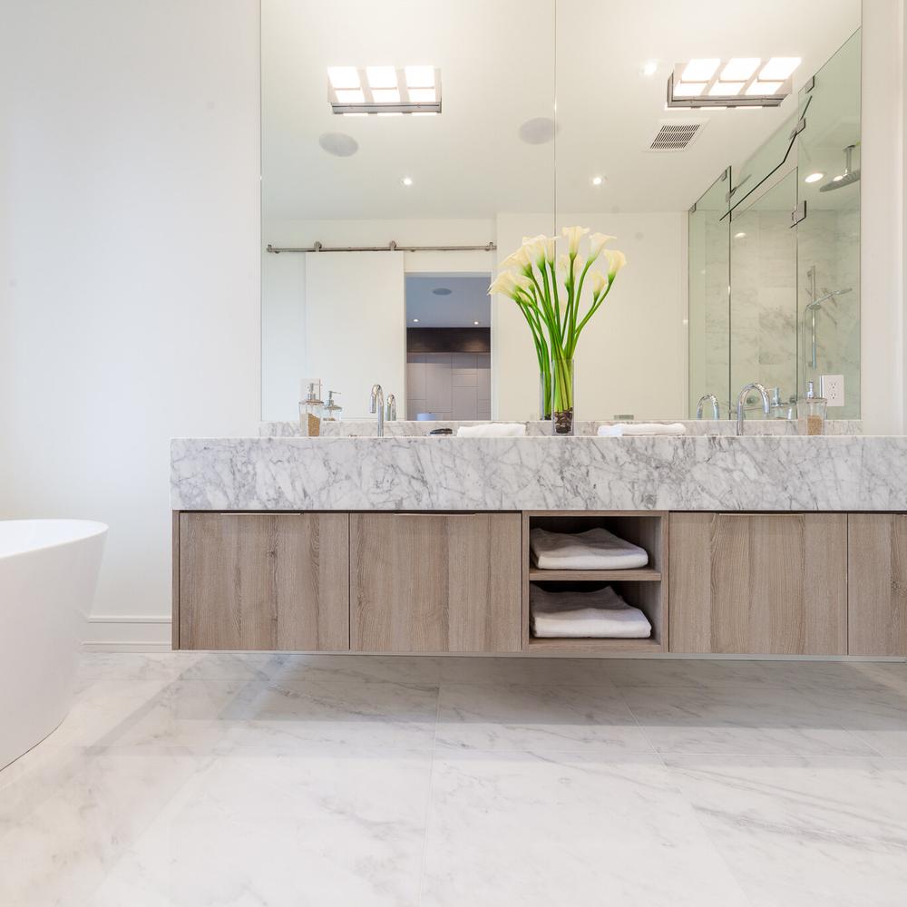 A spacious floating marble vanity complemented with modern chrome faucets and ample storage.