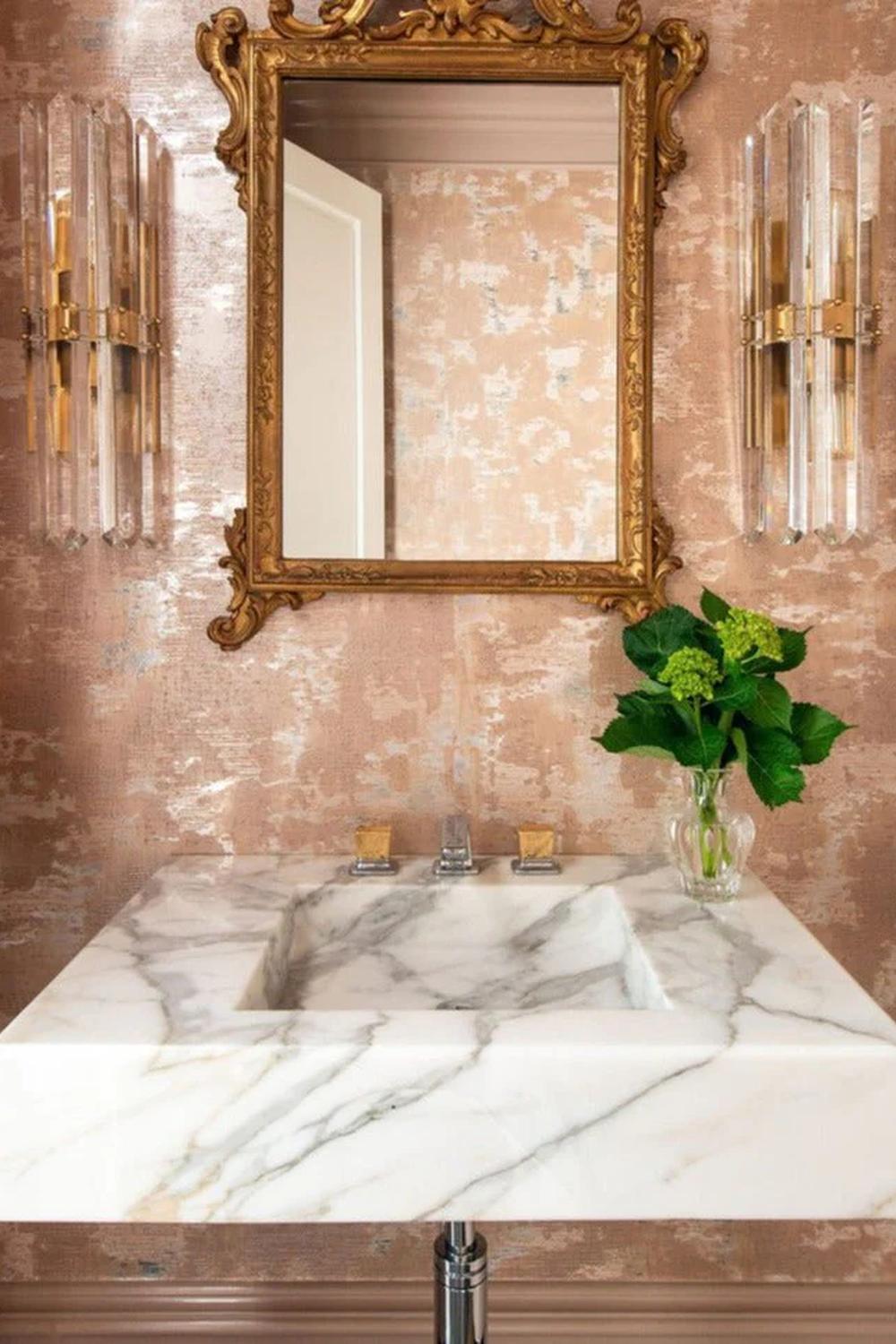 Sophisticated floating marble vanity paired with a decorative gold framed mirror, showcasing style and elegance.