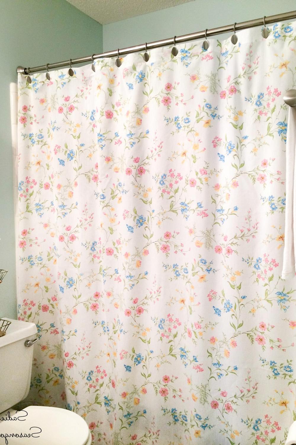 Whimsical floral shower curtain with fun accents bringing joy to bathroom decor.