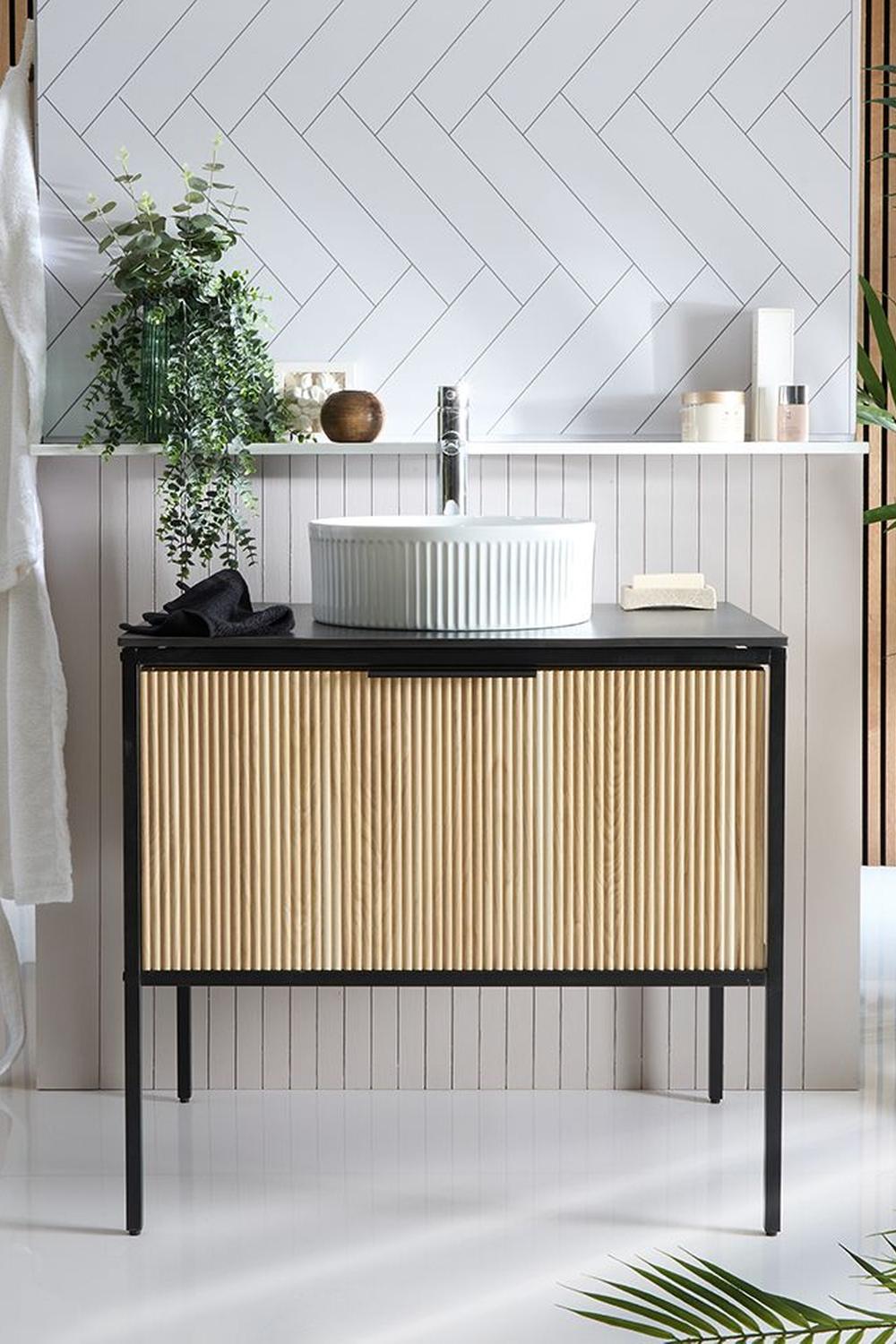 Fluted bathroom vanity with black metal base and light wood