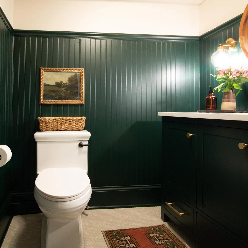 Baño acogedor con panelado verde bosque