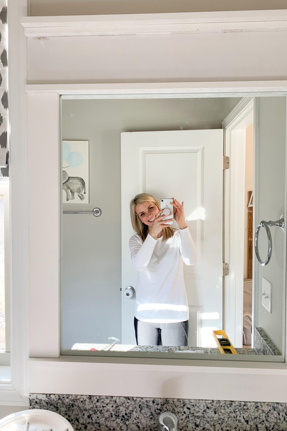 A tastefully framed mirror reflecting the cheerful ambiance of a stylish bathroom.
