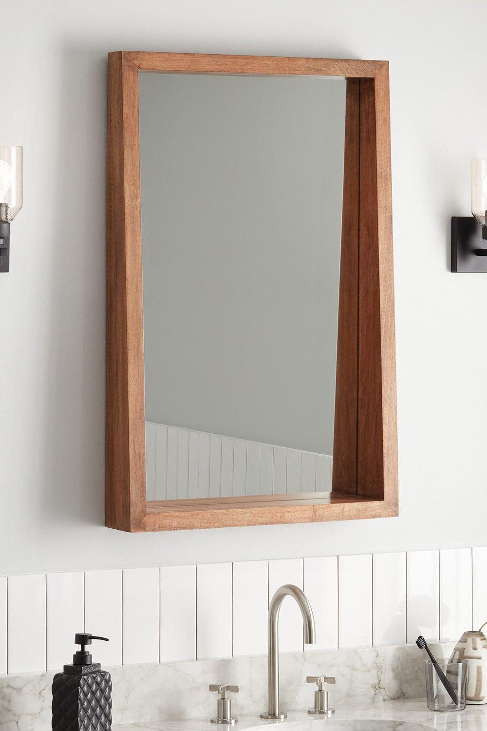 Light wood framed bathroom mirror reflecting a peaceful, stylish decor with elegance.