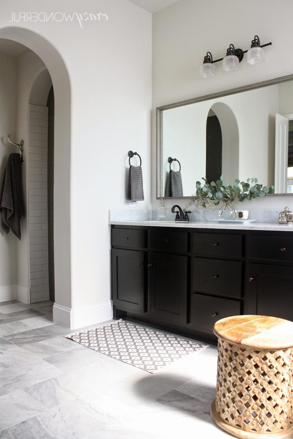 Stylish bathroom with two sinks and a striking rectangular mirror framed with subtle metallic accents.