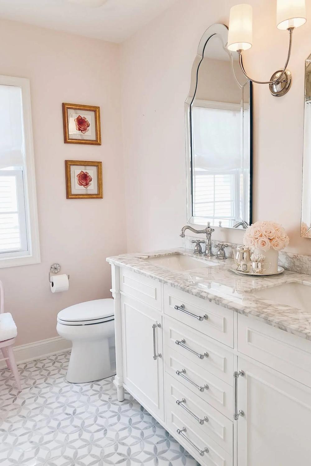 Baño estiloso con un toque femenino en tonos rosa suave y detalles elegantes