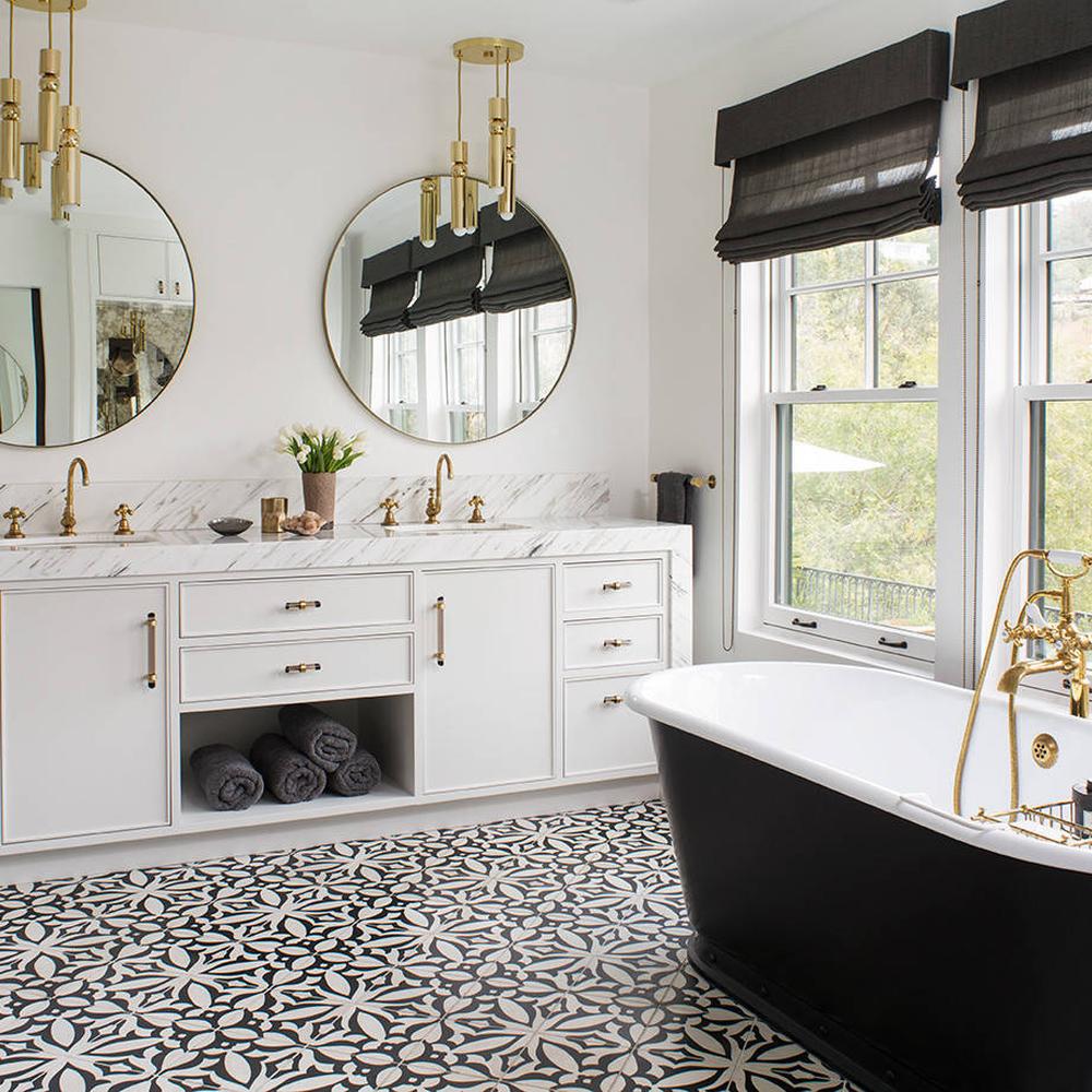 Baño sofisticado en blanco con detalles en oro y bañera negra