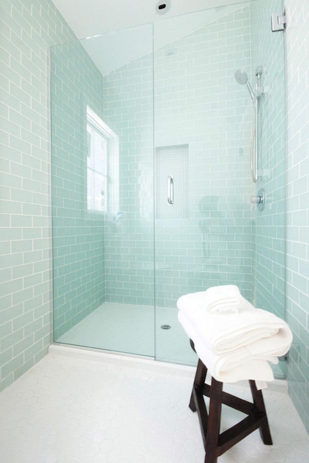 Minimalist modern bathroom featuring a walk-in shower and natural elements.