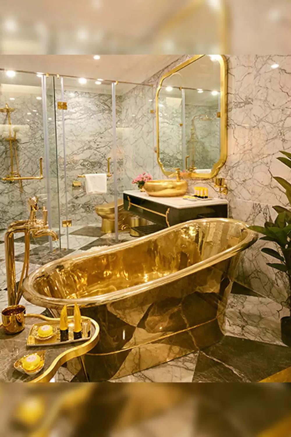 Baño moderno con bañera dorada como pieza central