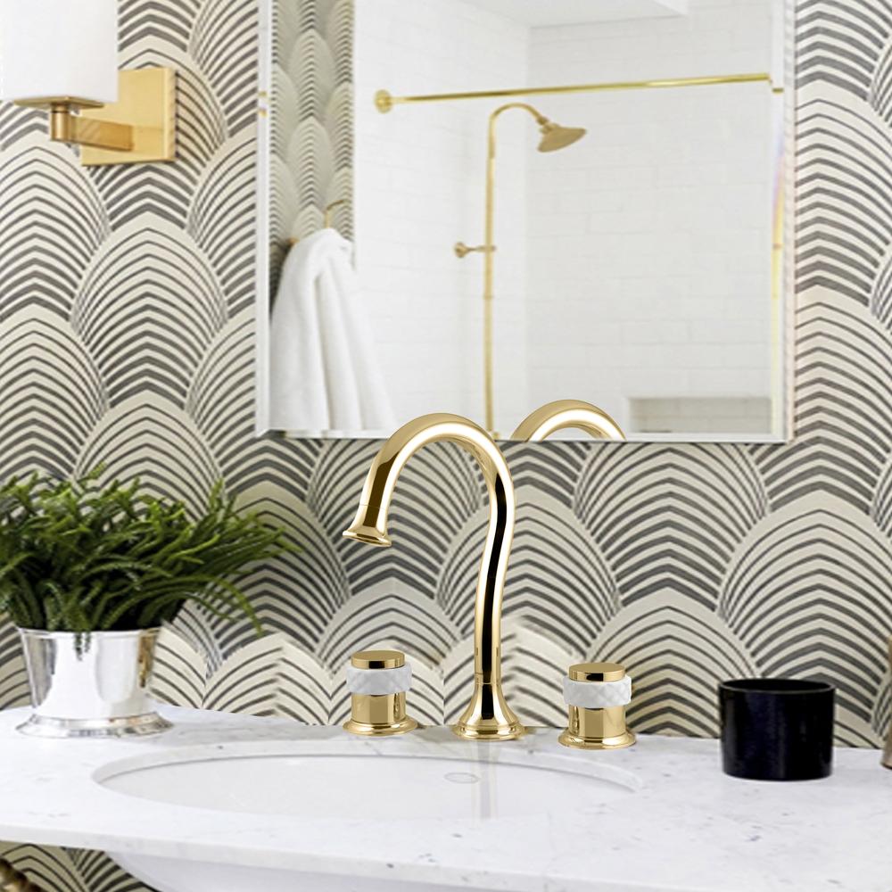 A chic bathroom featuring a gold faucet and round sink above polished marble.