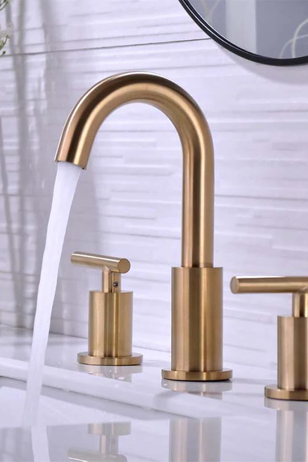 A stylish bathroom featuring gold faucets with a modern, functional design.