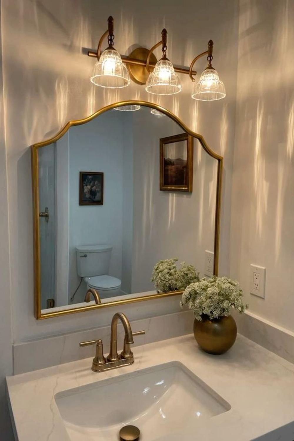 An inviting vanity area featuring elegant gold fixtures and a touch of natural decor.