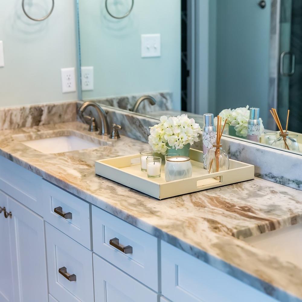 Elegante encimera de granito en un baño moderno con flores decorativas.