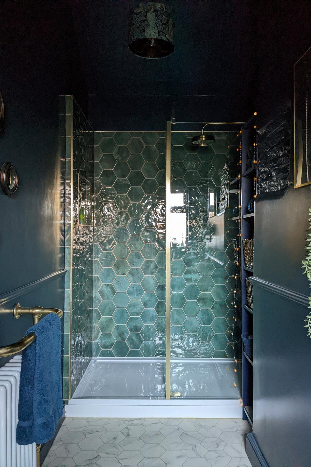 Modern bathroom featuring a stylish blend of green, navy, and gold elements.
