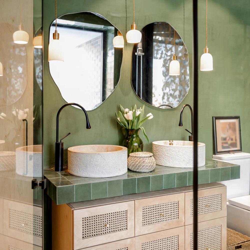 Baño moderno con tonos verdes y elementos orgánicos