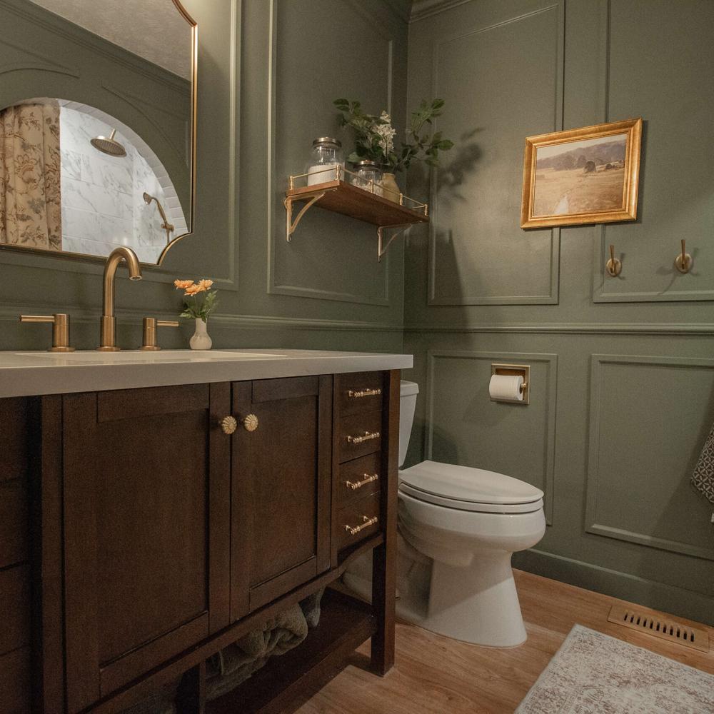 Baño elegante con ricas tonalidades verdes y elementos en madera