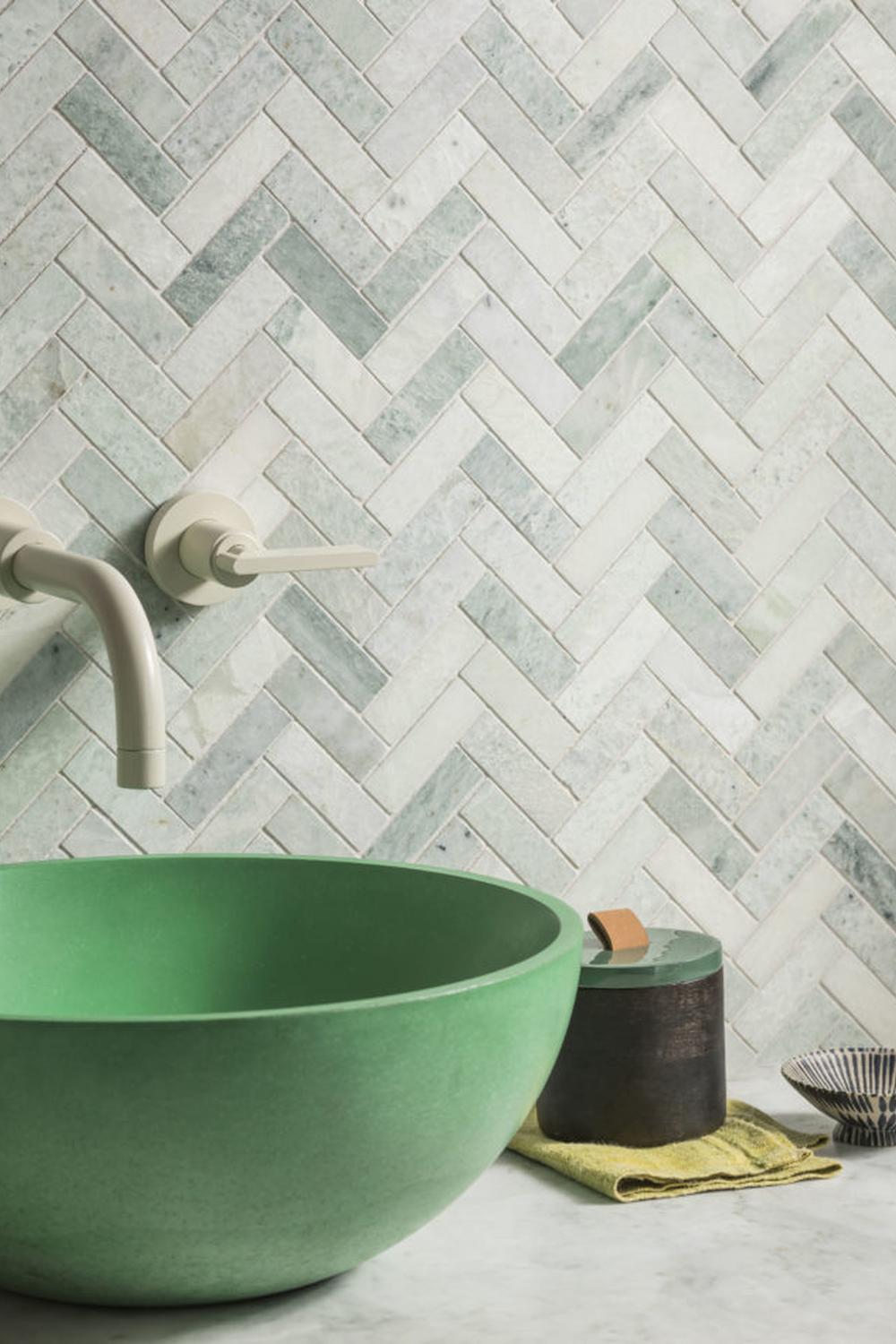 Baño con azulejos verde en sarga y lavabo redondo en color mate.