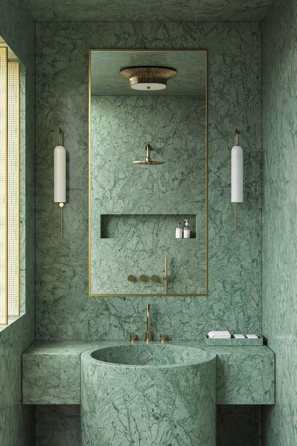 A modern bathroom featuring a circular vanity and green marble accents.