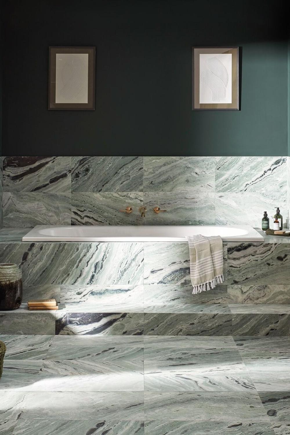 A luxurious green marble bathroom featuring minimalist design and framed art.