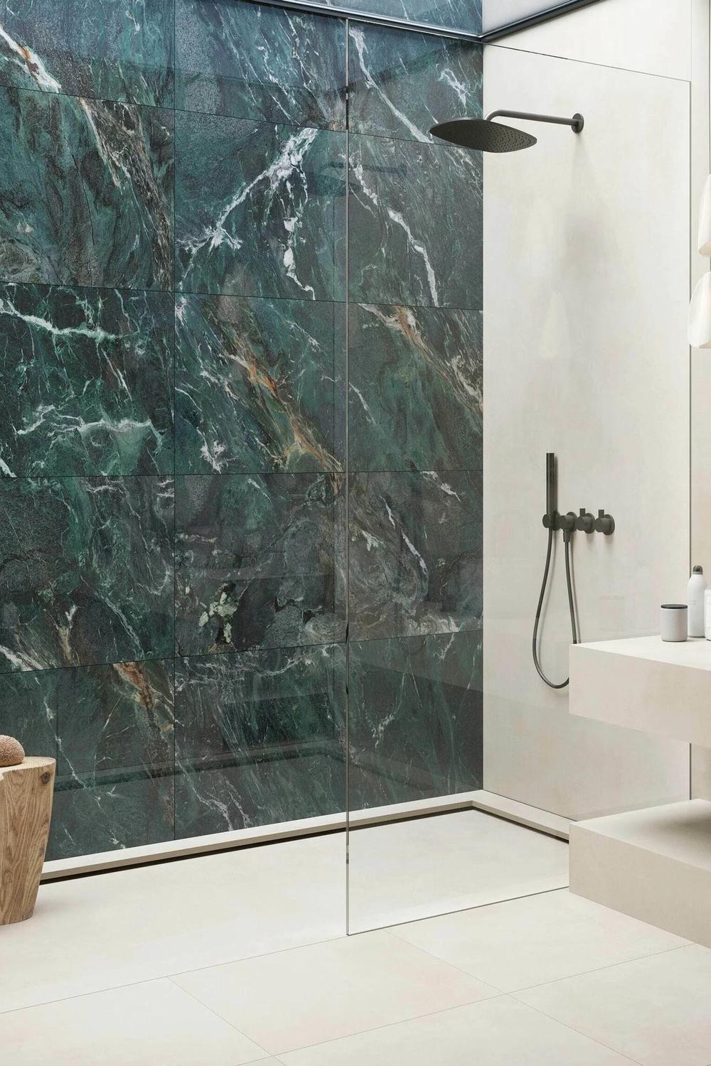 An elegant bathroom with a striking green marble feature wall and modern fixtures.