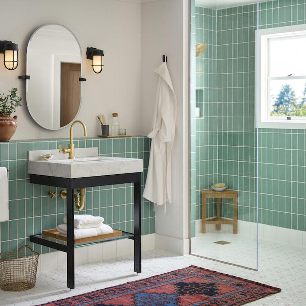 Stylish bathroom with green tiles and marble countertops.