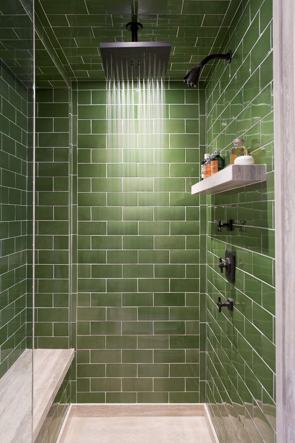 Shower area featuring vibrant green subway tiles and a square rain showerhead.