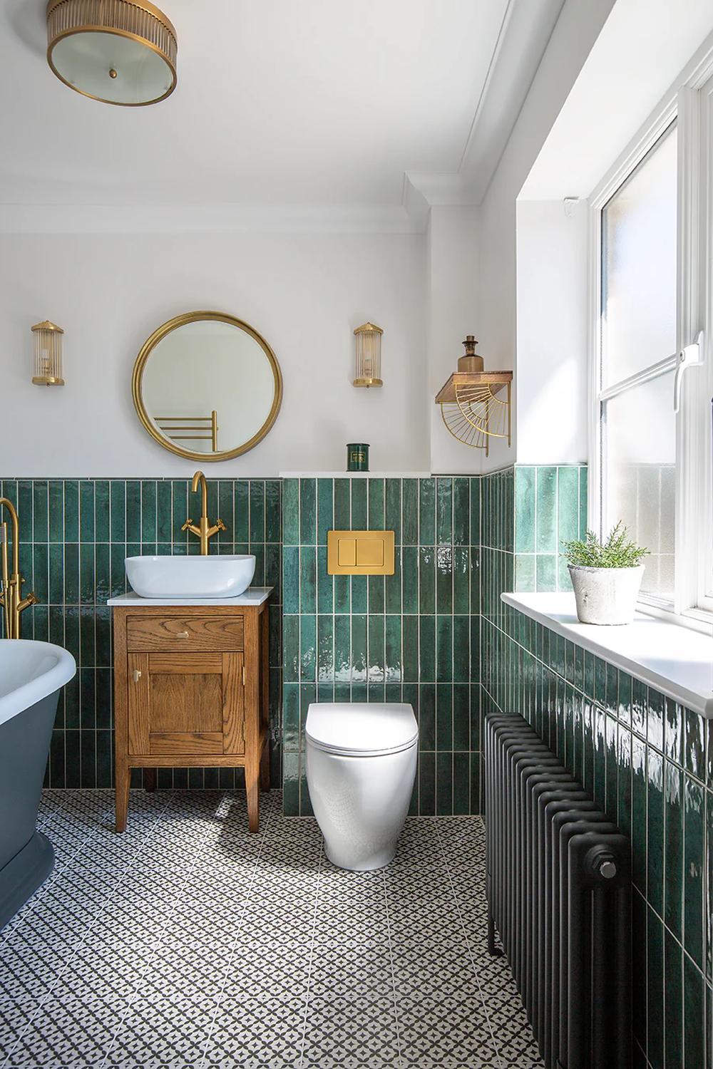 Bathroom featuring cohesive design with dark green tiles, wooden accents, and modern fixtures.