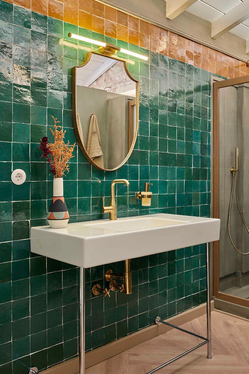 Baño con azulejos verde Zellige y detalles en naranja
