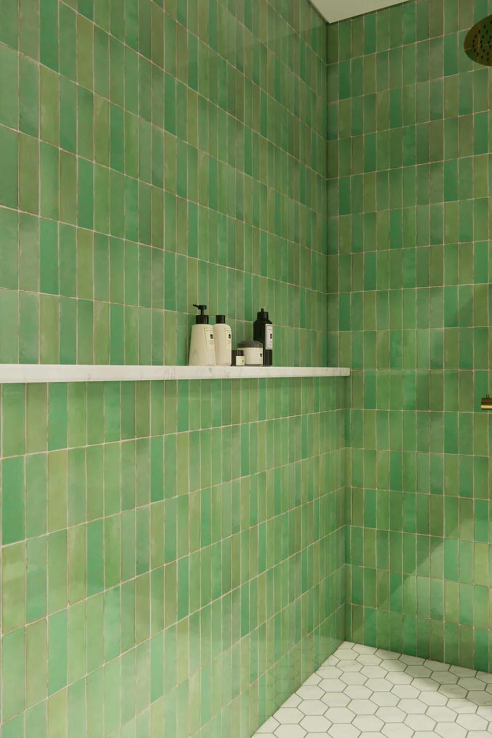 Baño moderno con azulejos verdes Zellige y estanterías blancas