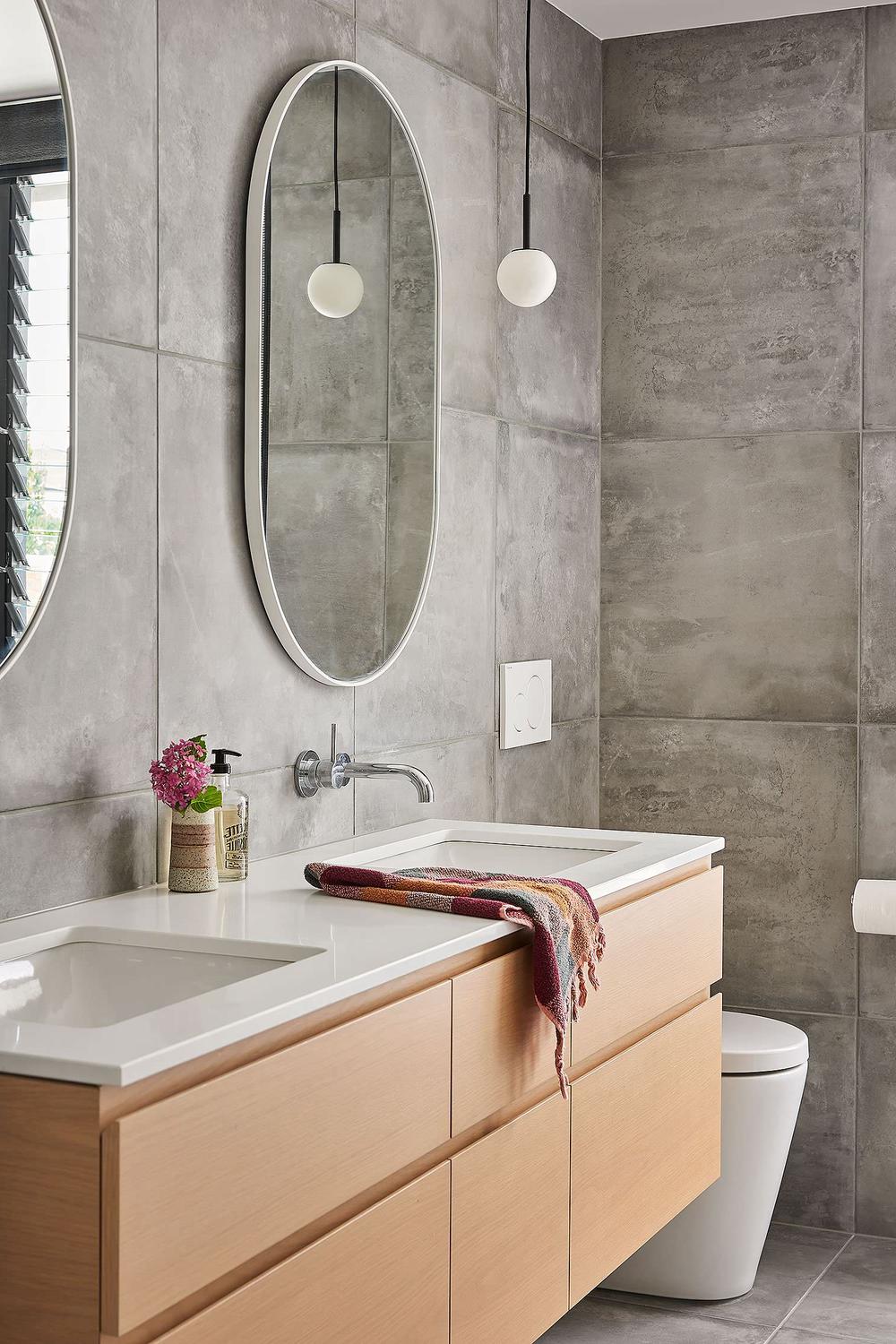 Monochromatic color scheme creates a seamless look in a grey tile bathroom