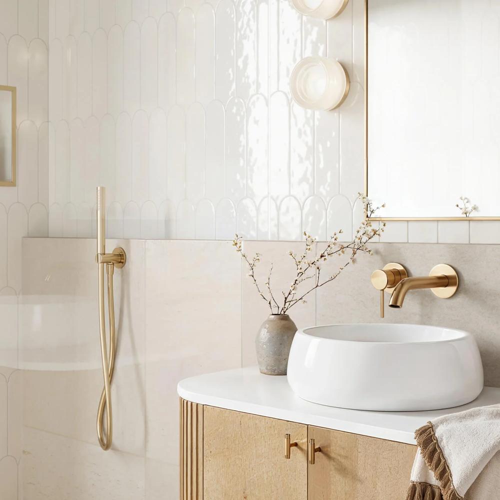 A bathroom showcasing elegant textured wall tiles, a marble sink, and decorative elements