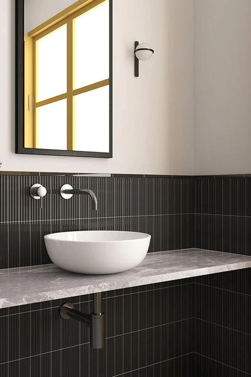 A bathroom with herringbone-patterned tiles, modern fixtures, and a pop of color