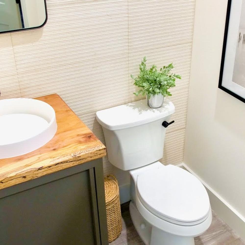 A compact bathroom with natural wood finishes, modern sink, and decorative elements