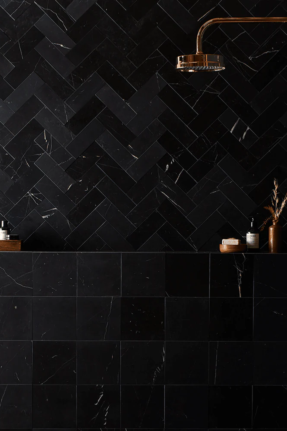 Bathroom wall adorned with herringbone-patterned black tiles.