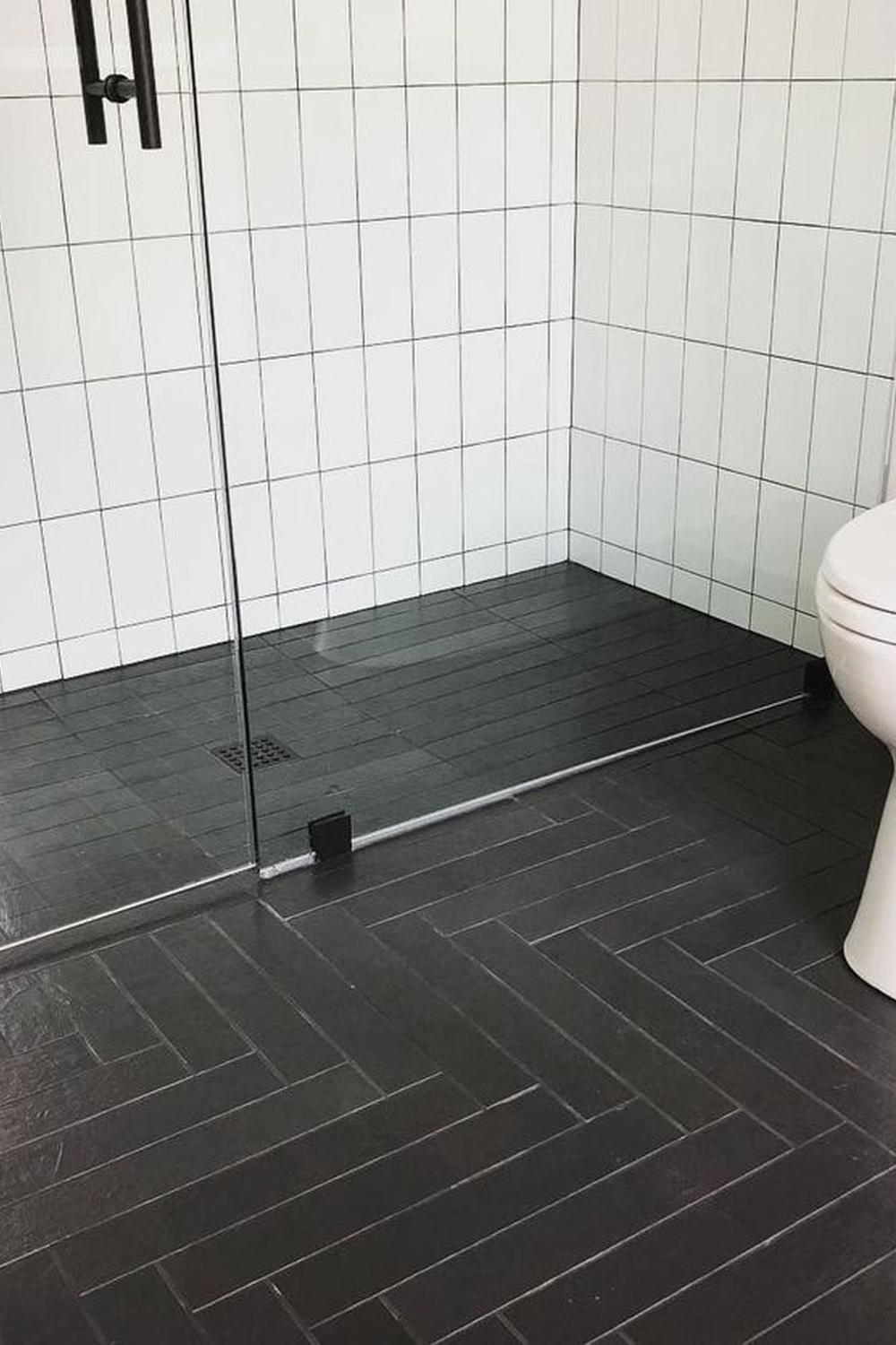 Modern bathroom with herringbone black tile flooring.