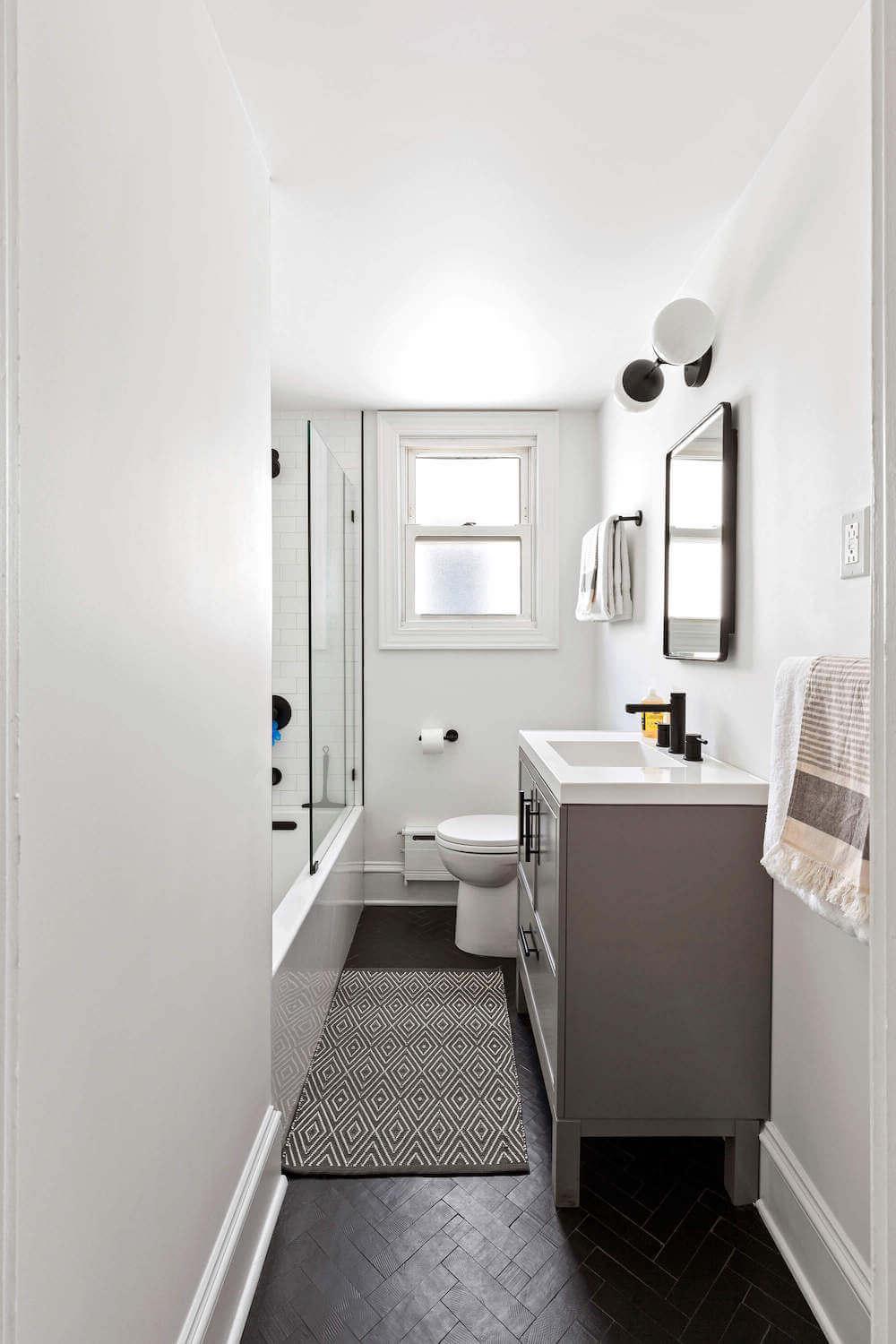 Stylish bathroom with herringbone black tile flooring.
