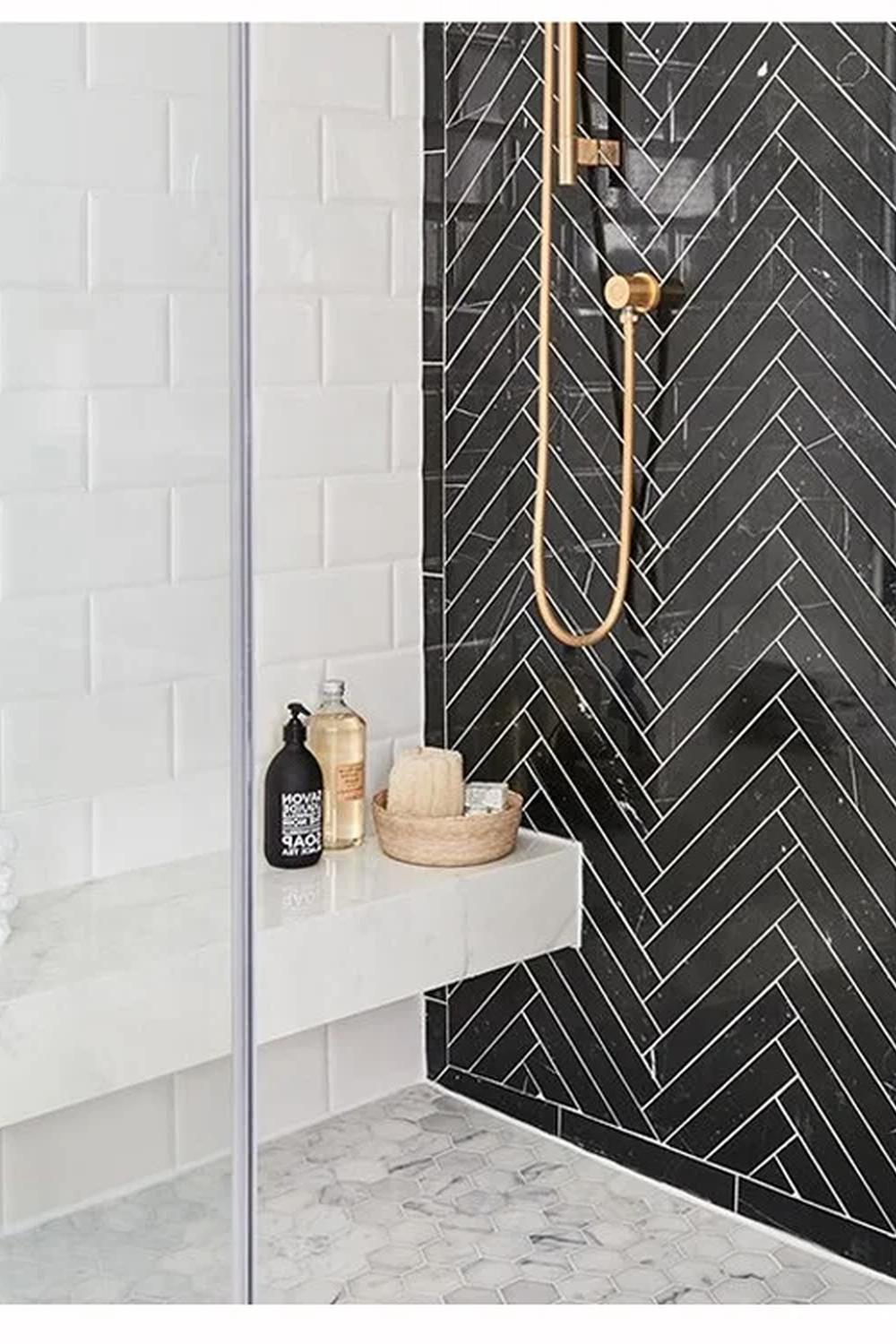 Modern stylish shower area featuring herringbone black tiles.