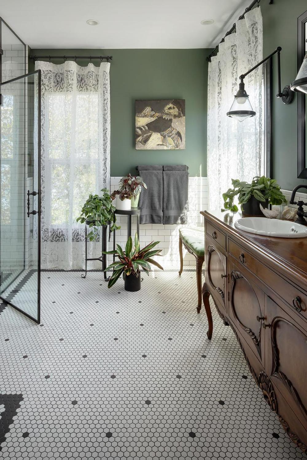 Eclectic bathroom featuring deep green walls and hexagon tiles.