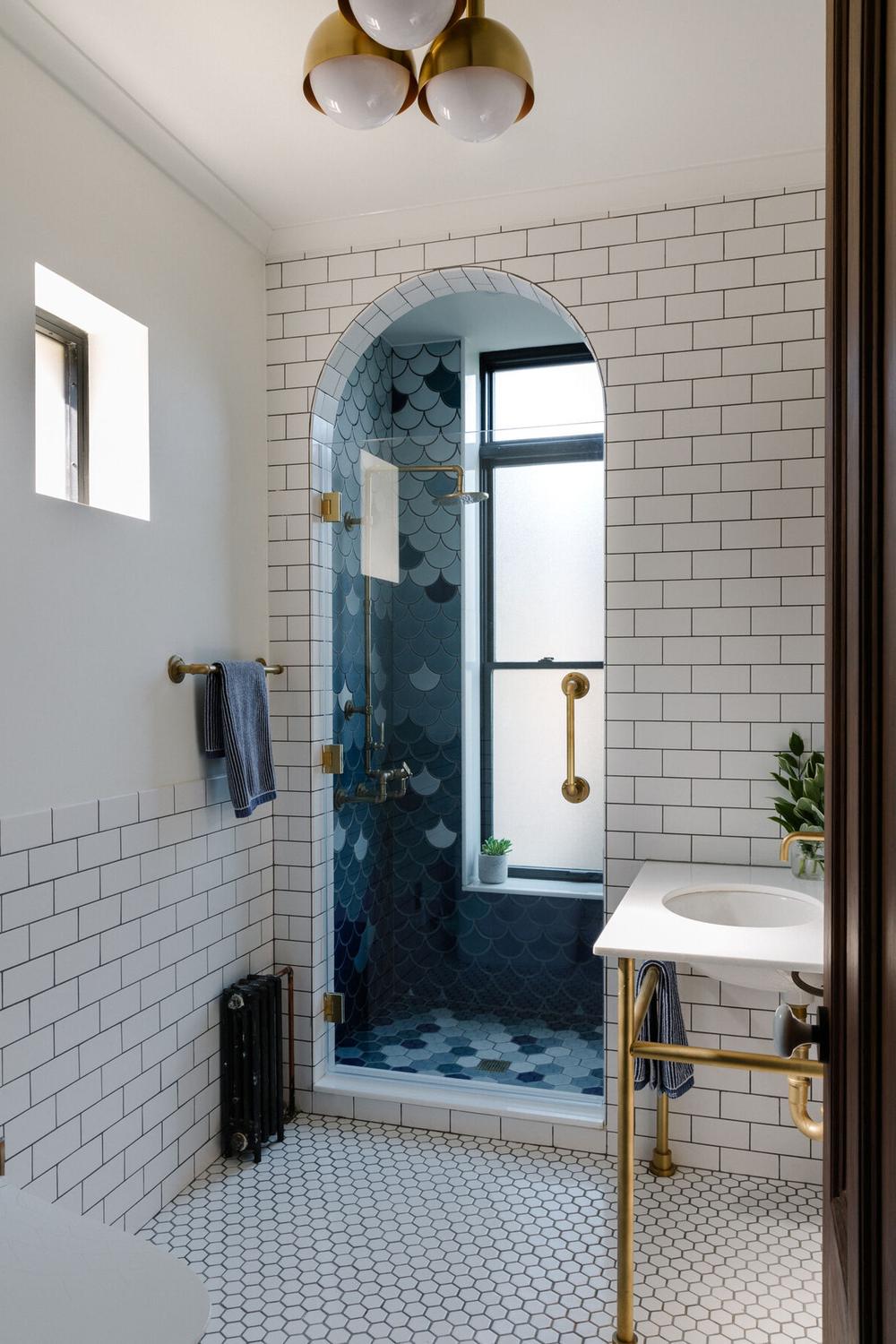 Suelo de baldosas hexagonales blancas con pared azul en un baño elegante