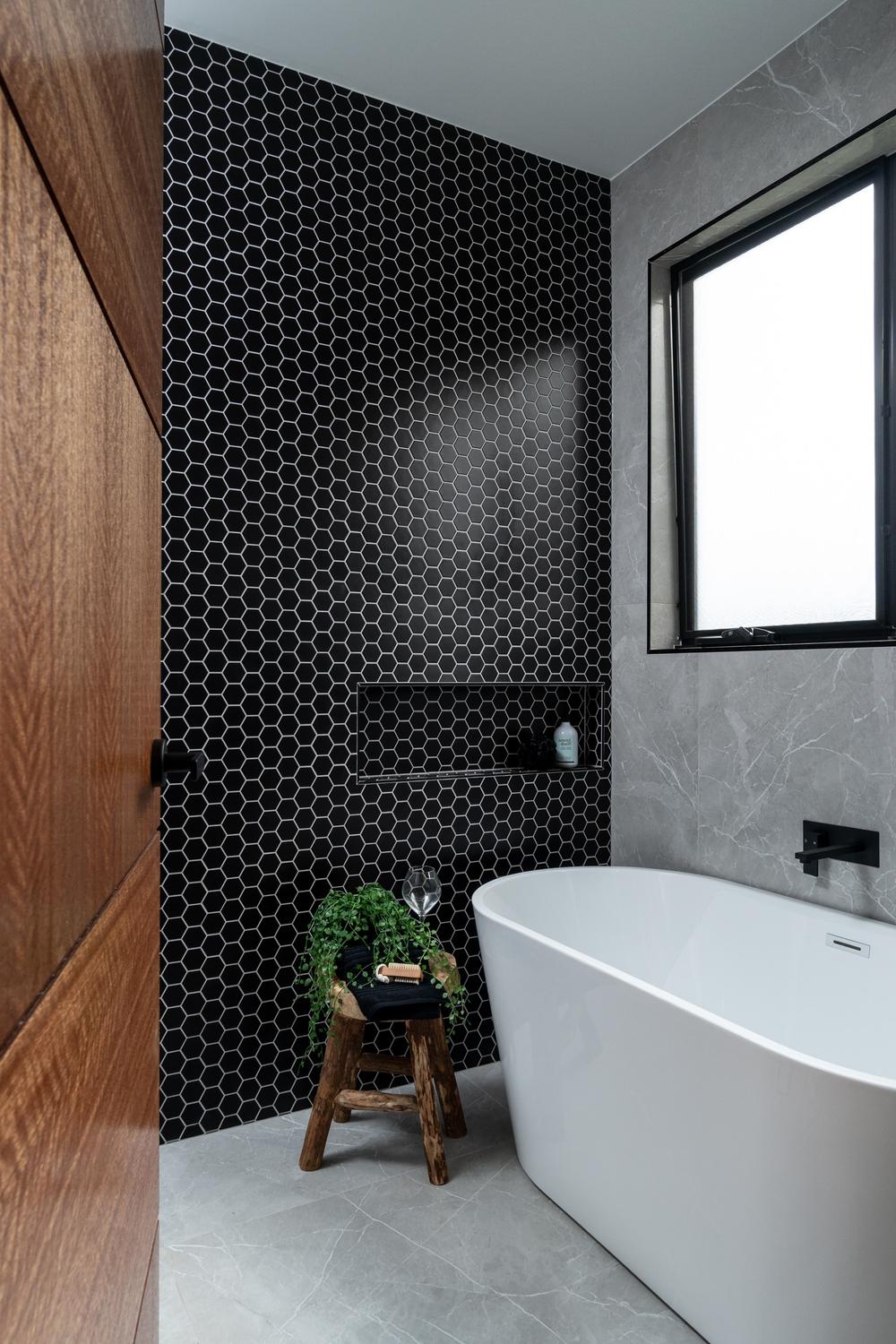 black hexagon tile shower wall design in a modern bathroom