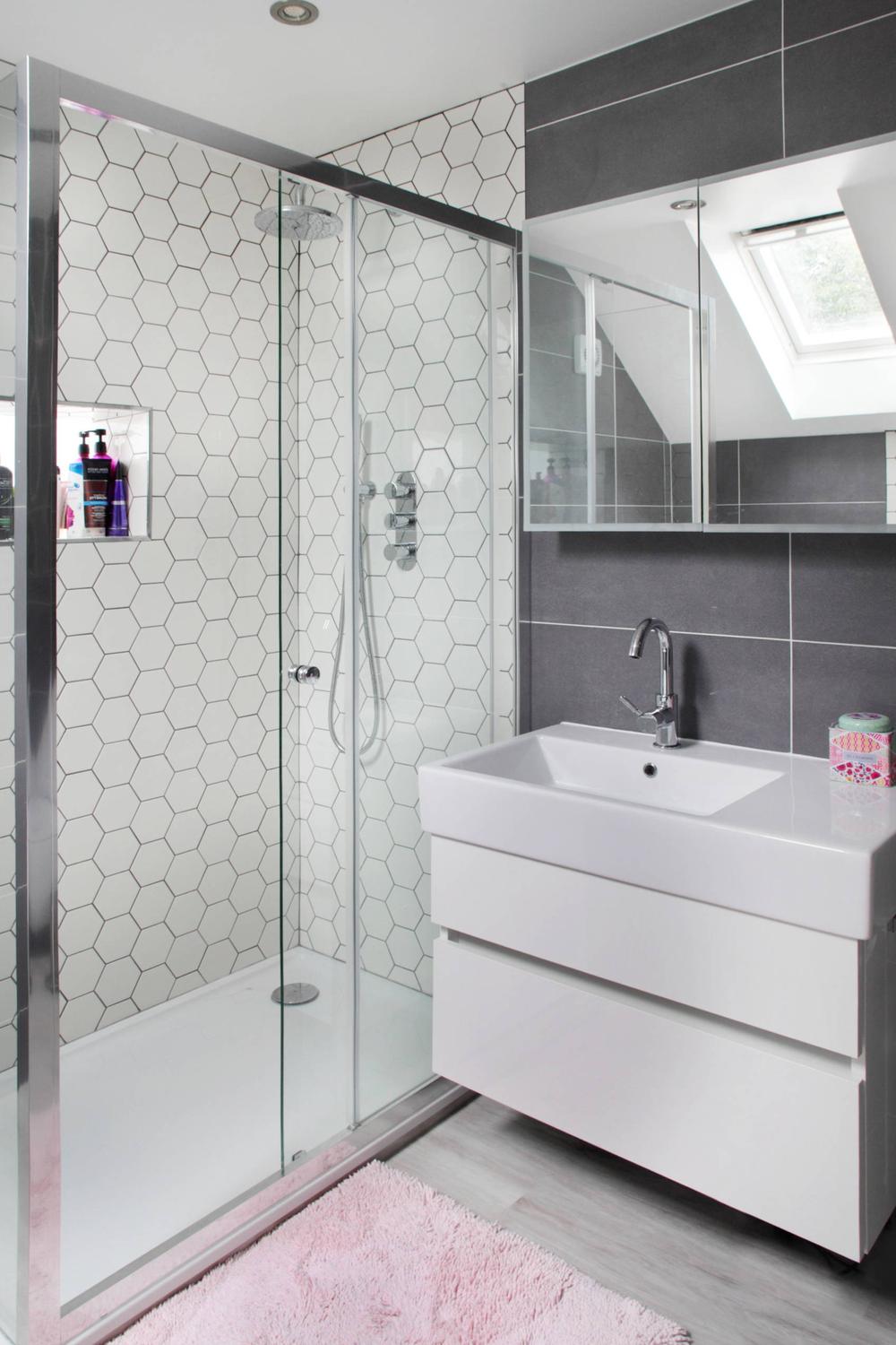 Elegant white hexagon tile shower with frameless glass enclosure