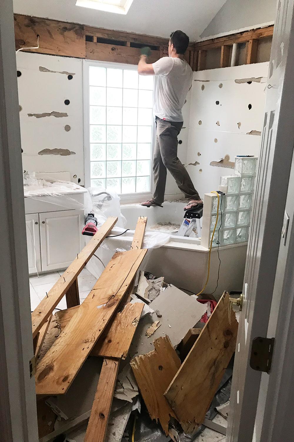 Busy scene of a person renovating a bathroom with visible soffit area