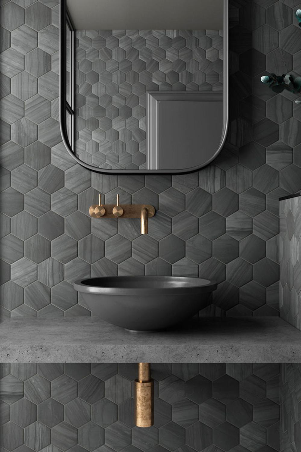 A modern industrial bathroom with a dark green hexagonal tile wall and concrete accents.