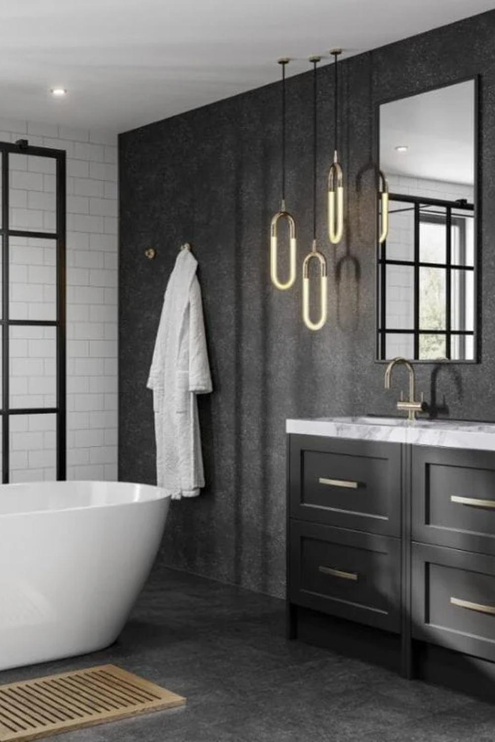 A refined industrial bathroom featuring dark cabinetry, pendant lights, and a freestanding oval bathtub.